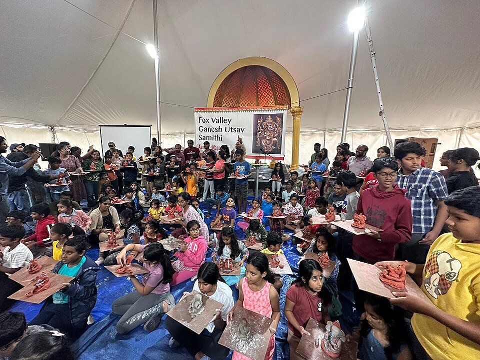 Children learning to make Ganesha images in a workshop; this photograph illustrates learning the craft rather than a professional production line.